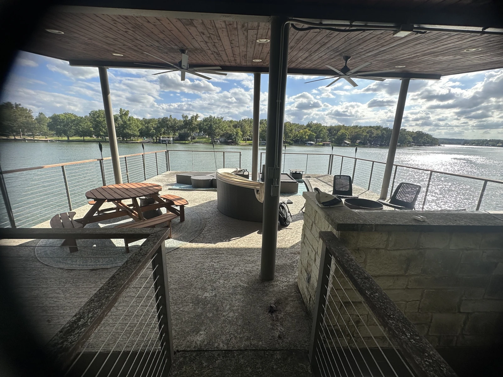 Far View dock's upper gathering deck, with cable railing, a picnic table and a timber ceiling overlooking the lake.